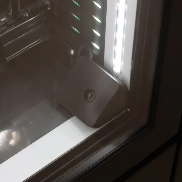 Small camera sensor mounted in the corner inside a cooler door